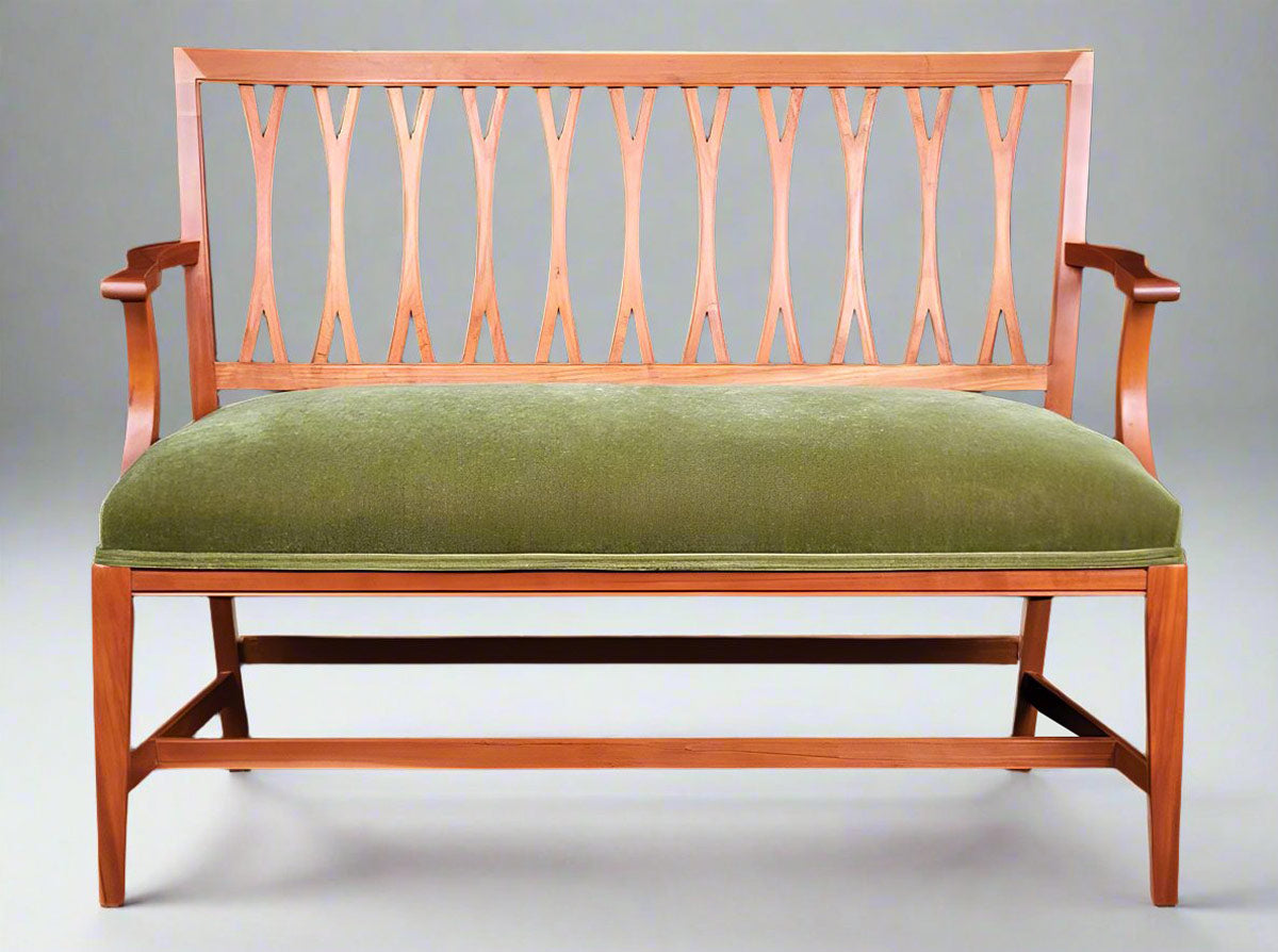 carved bench with latticed back and upholstered in a green velvet cushion