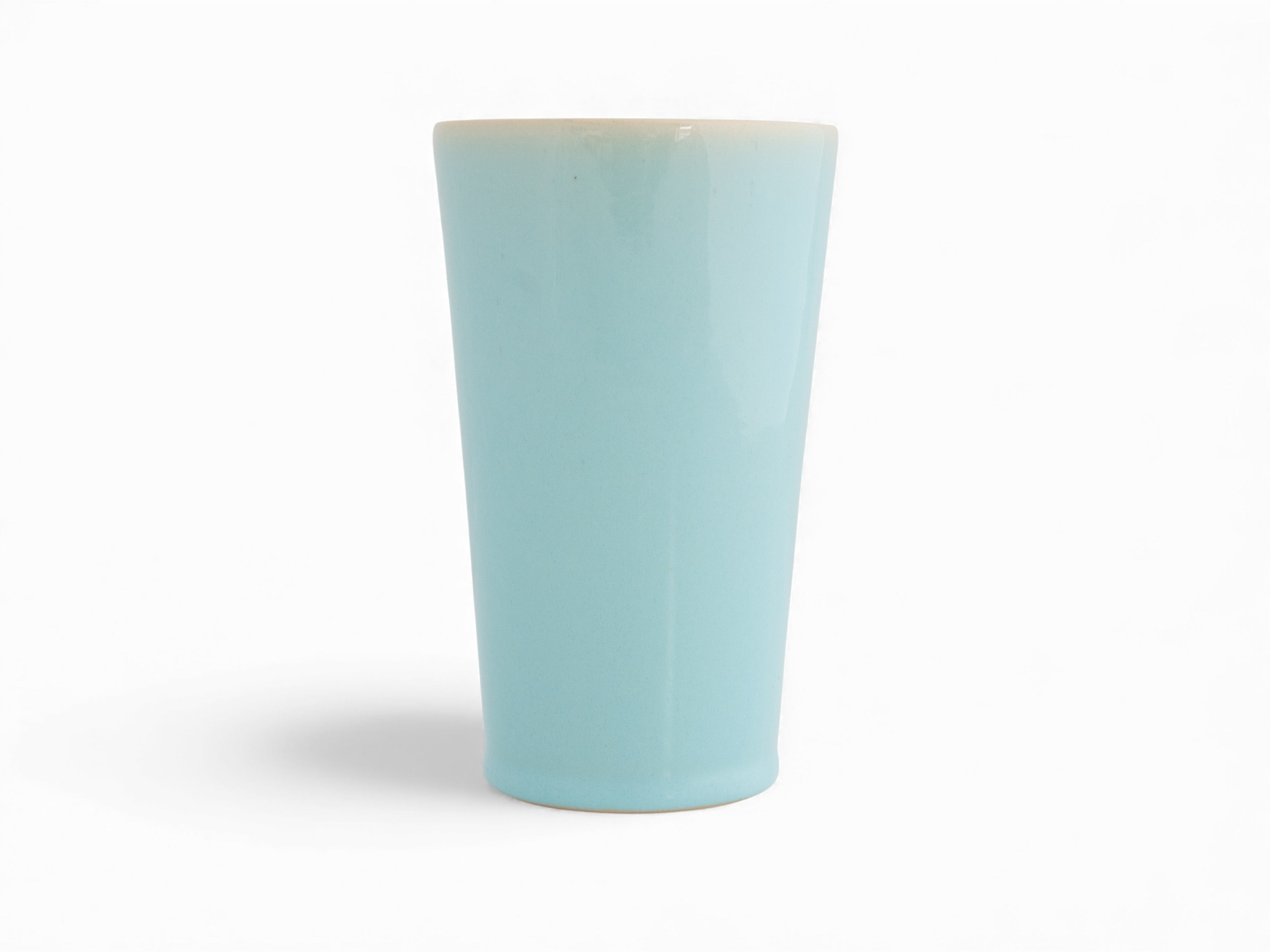 A hand-thrown, hand-dipped blue sky beaker stoneware vase with a glazed finish.