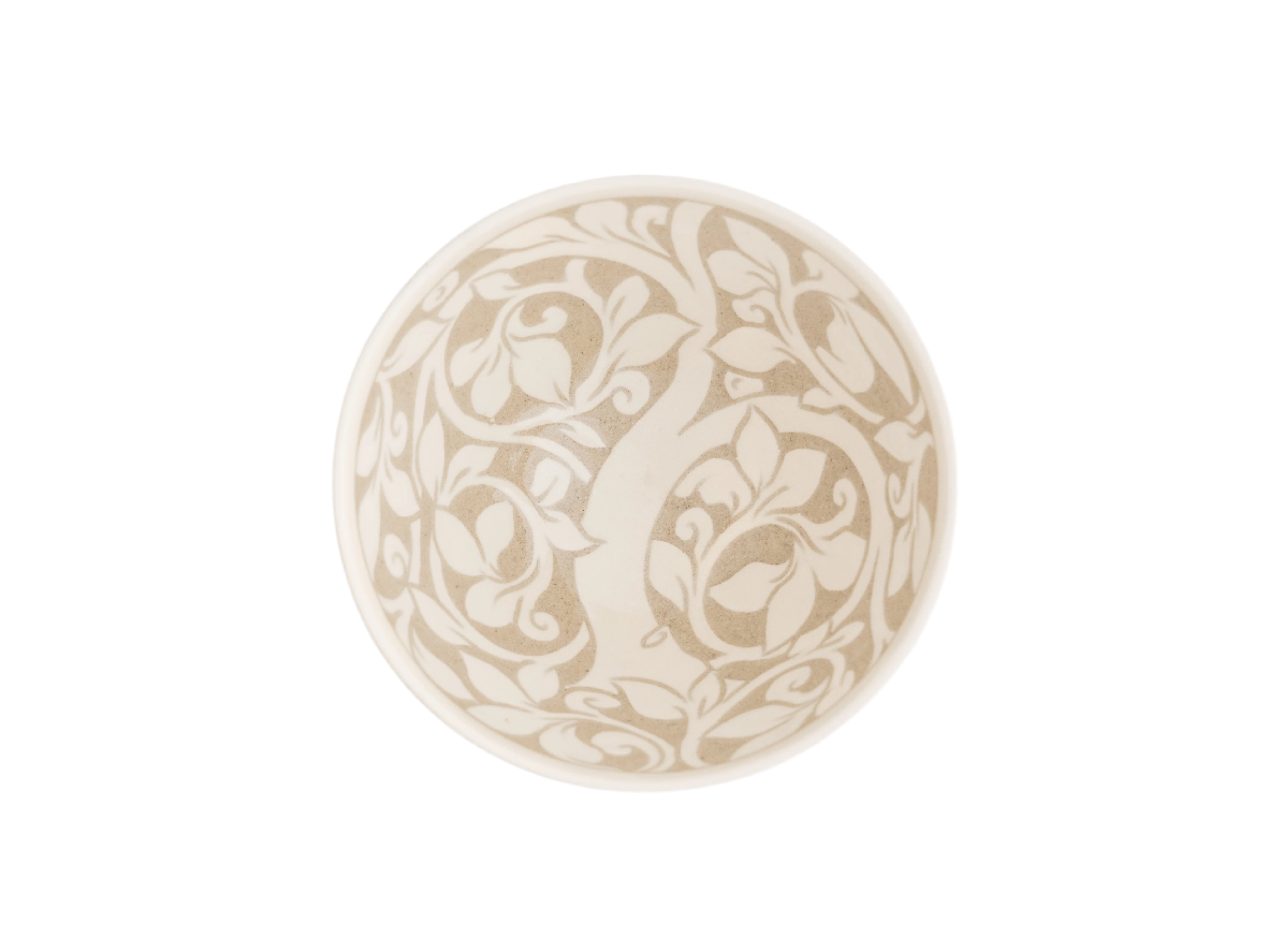 a cream-colored ceramic bowls with carved tree-of-life pattern