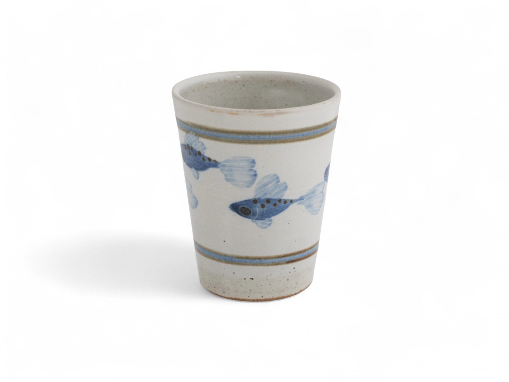 A hand-thrown stoneware beaker with blue painted fish pattern