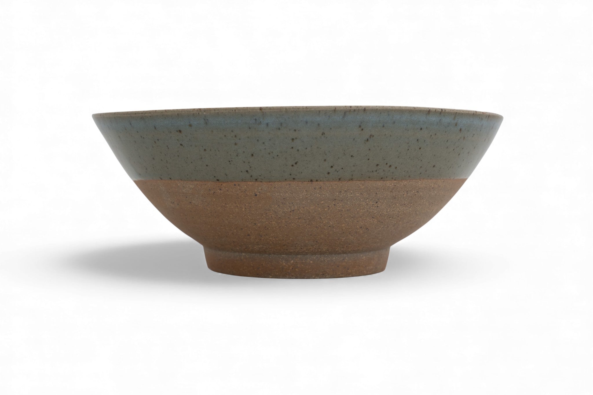 Handmade stoneware serving bowl with raw clay and celadon glaze
