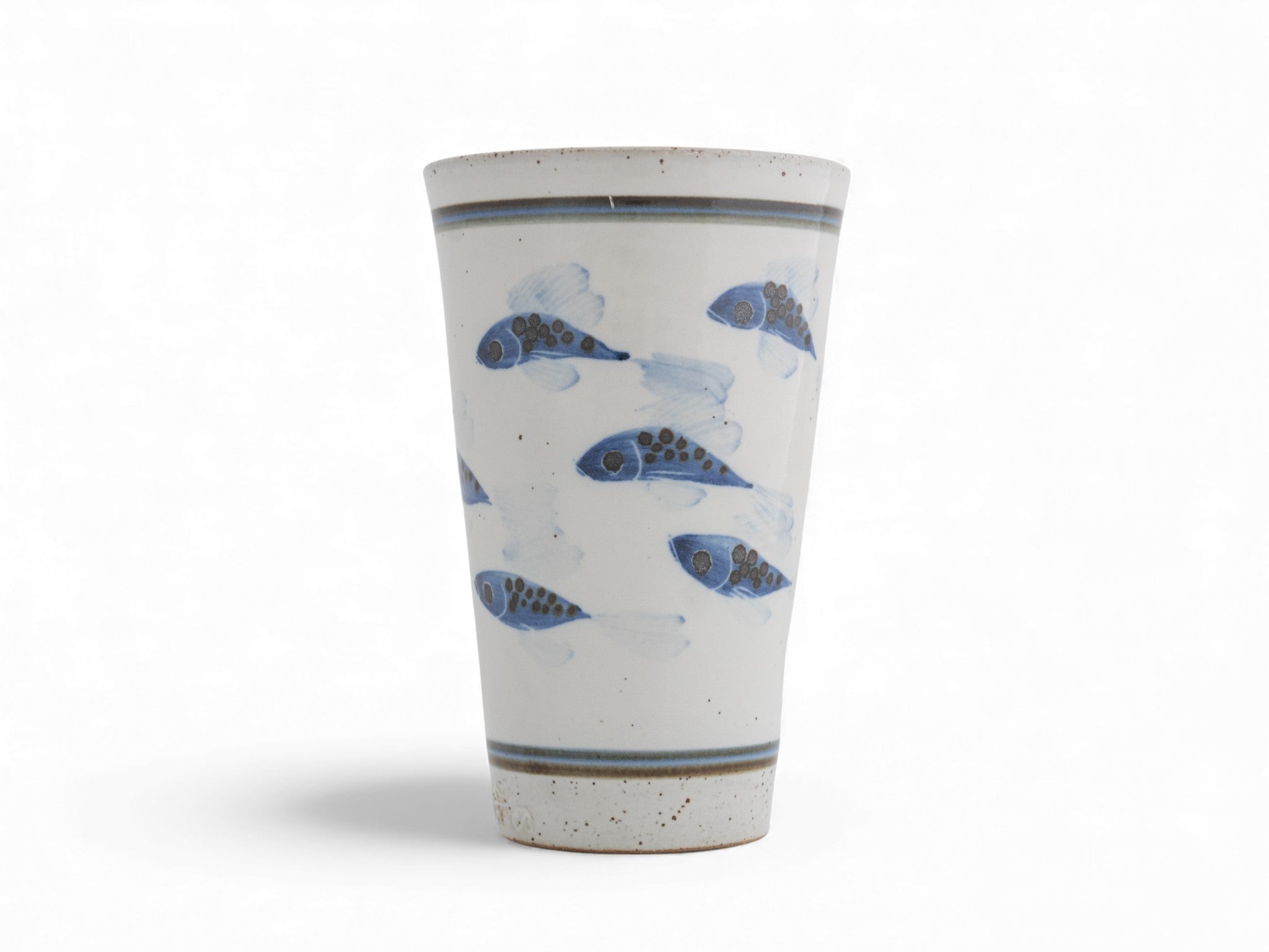 A hand-thrown stoneware beaker with blue painted fish pattern
