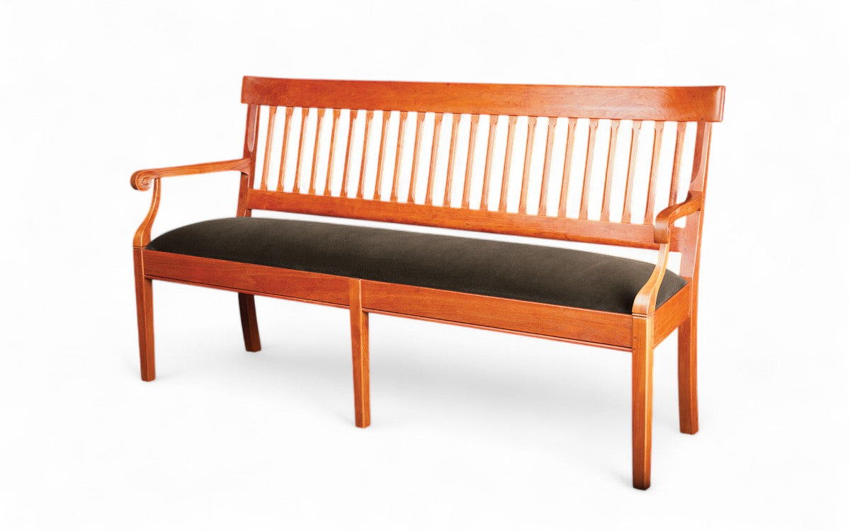 Wooden bench with a black cushion on a white background