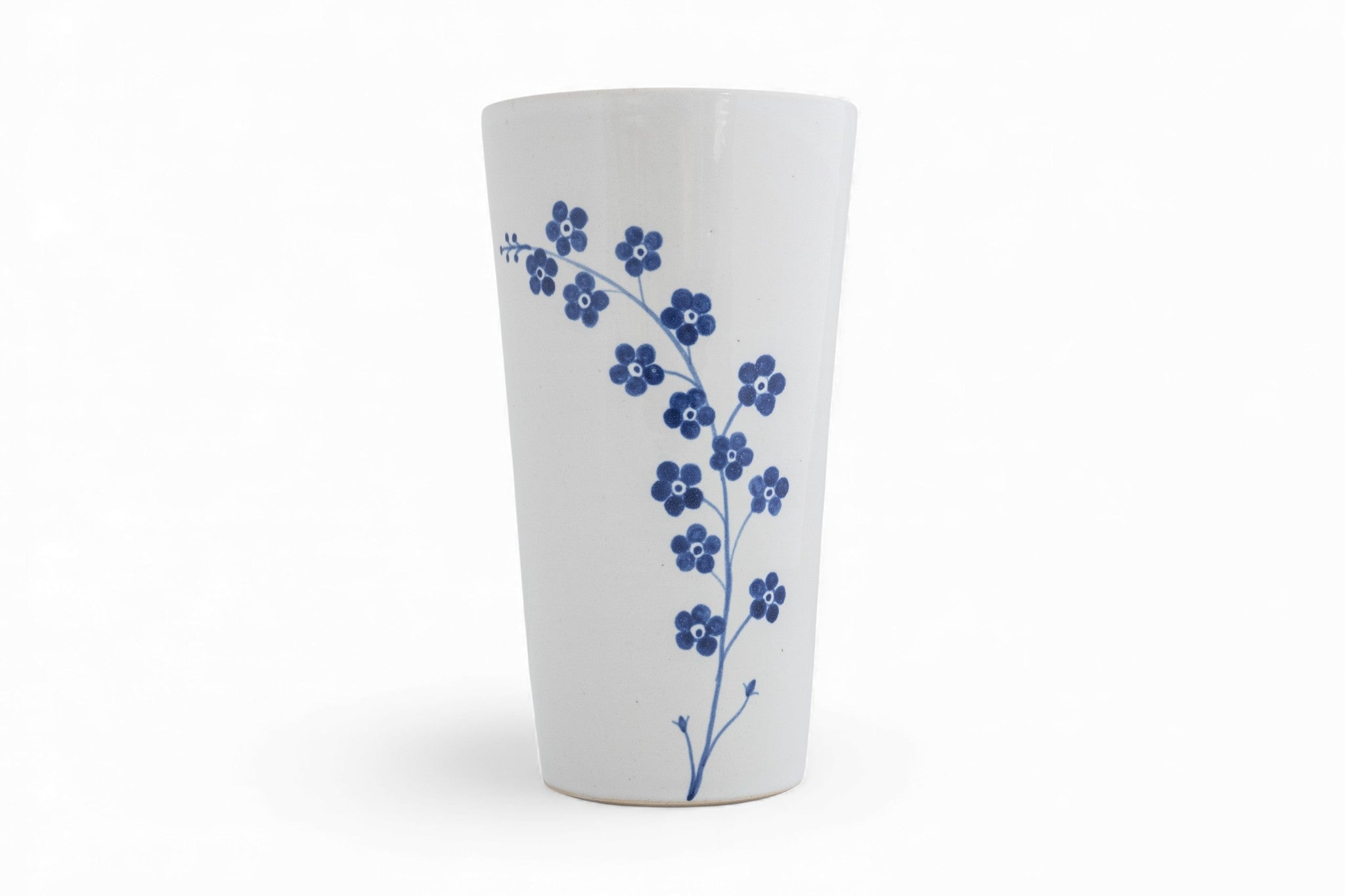a hand thrown stoneware beaker cup with painted forget-me-not flowers