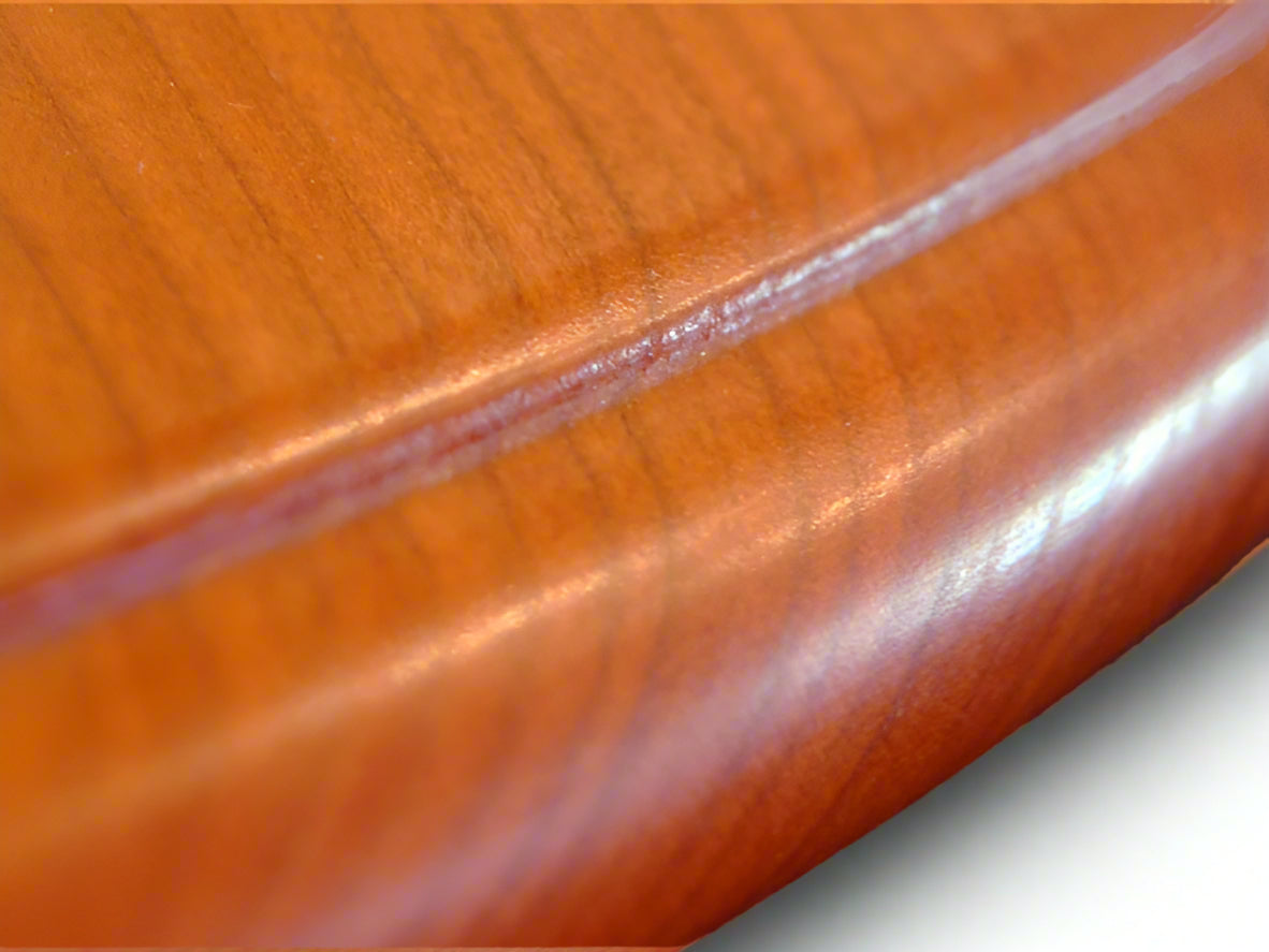 A classic wooden pedestal dining table with hand-carved legs, featuring a thumbnail edge on the top